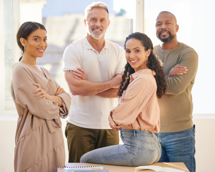 4 people smiling and looking towards a camera